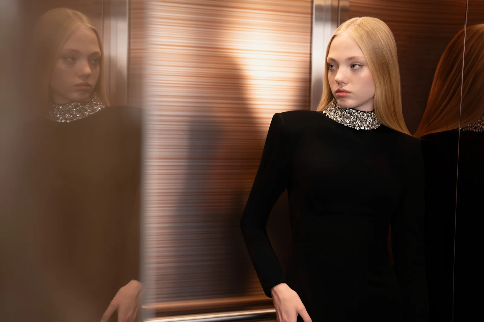 A black formalwear silhouette against directional light and architectural shadows